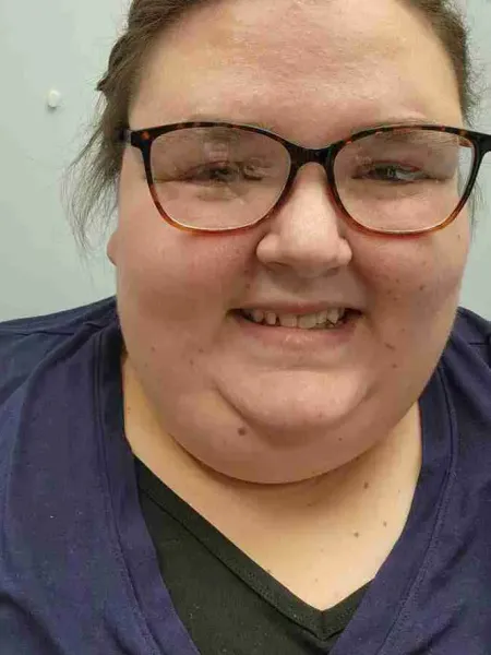 Emily, woman with glasses smiles