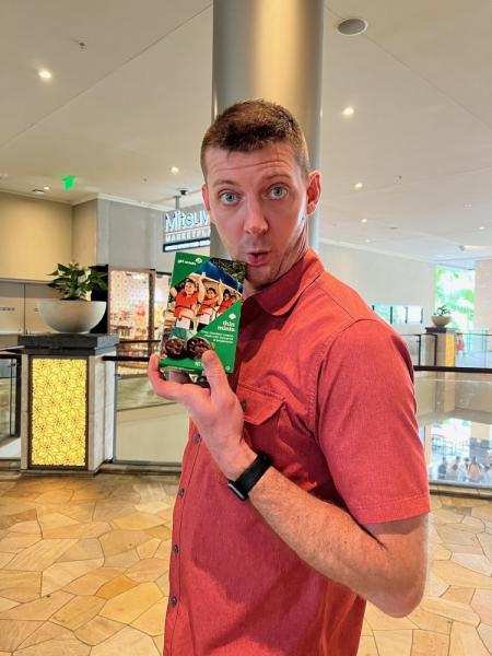 Shane Picha holding a box of girl scout thin mint cookies.